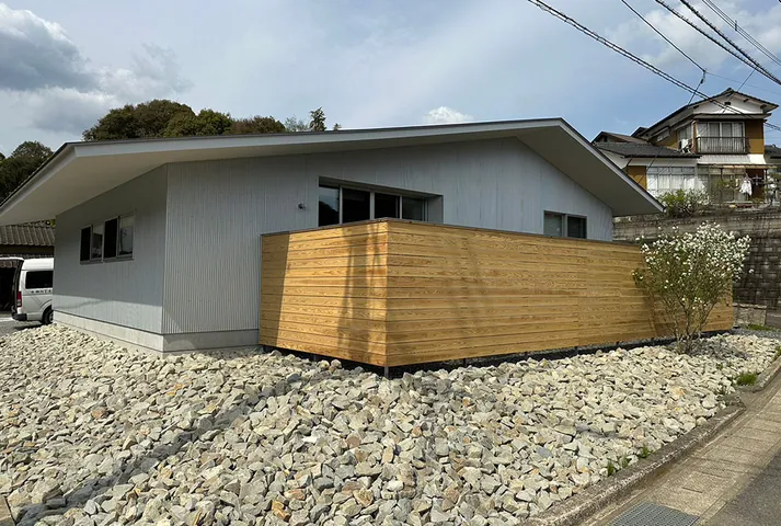 施工事例：白い外壁と木の塀の平屋