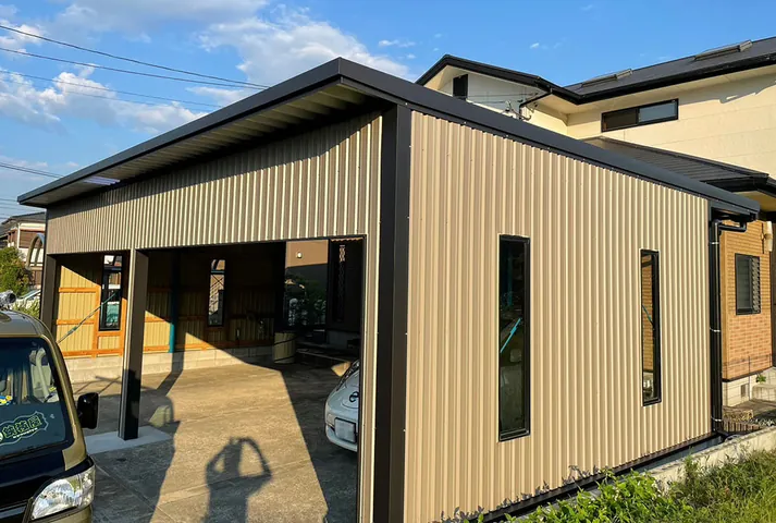 施工事例：ベージュの金属外壁とカーポートのある住宅