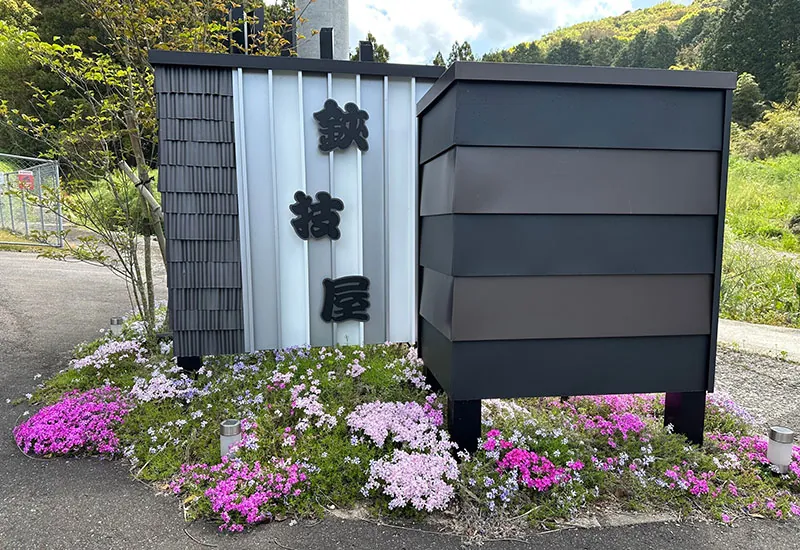 鋏技屋の看板と花壇